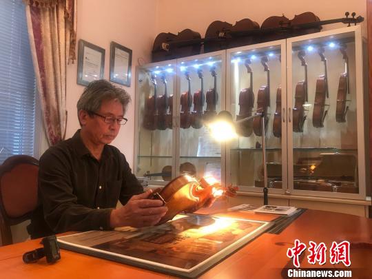 陆伟光在研究提琴技艺。 陶社兰 摄 ..