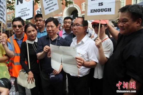 伦敦华埠商会主席邓柱廷(前左3)等侨领在展示致英国内政部的申诉信函。 <a target='_blank' >中新社</a>记者 张平 摄