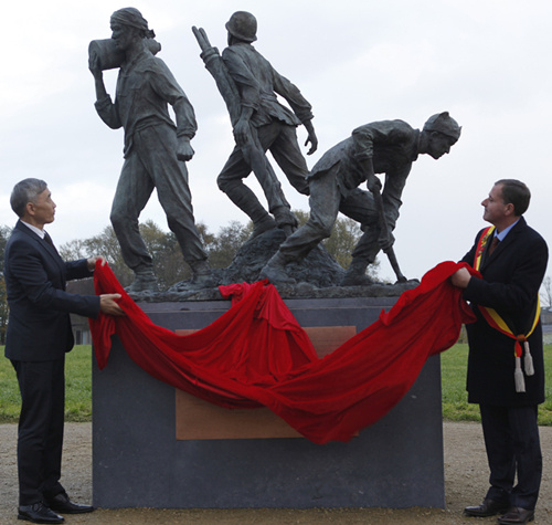 当地时间11月15日,一战华工青铜纪念雕像在比利时西部与法国接壤的波普林格市正式落成。图为中国驻比利时大使曲星与波普林格市市长德雅盖共同为雕像揭幕。(图片来源:<a target='_blank' href='http://www.chinanews.com/'>中新社</a>) ..